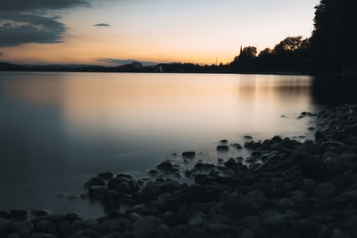 日落时水体上的黑色岩石